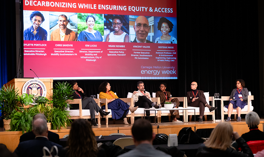 Image of panel speakers seated on a stage