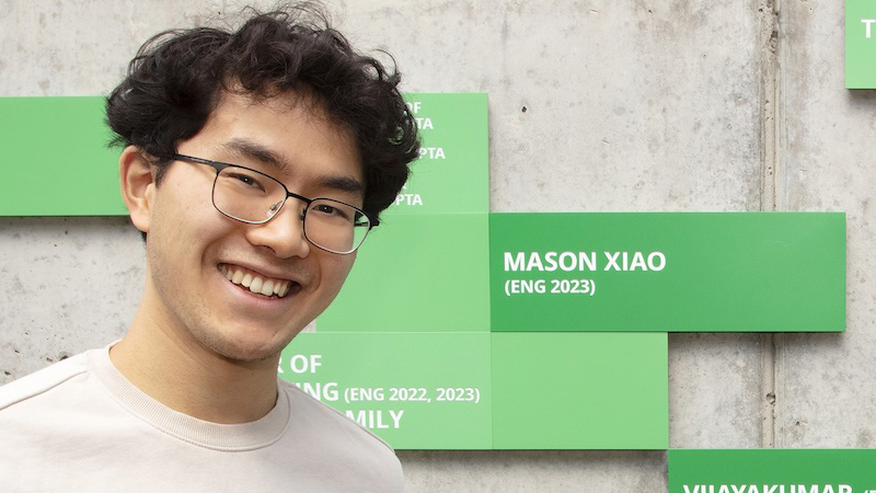 A smiling young man wearing glasses in front of the FOEB