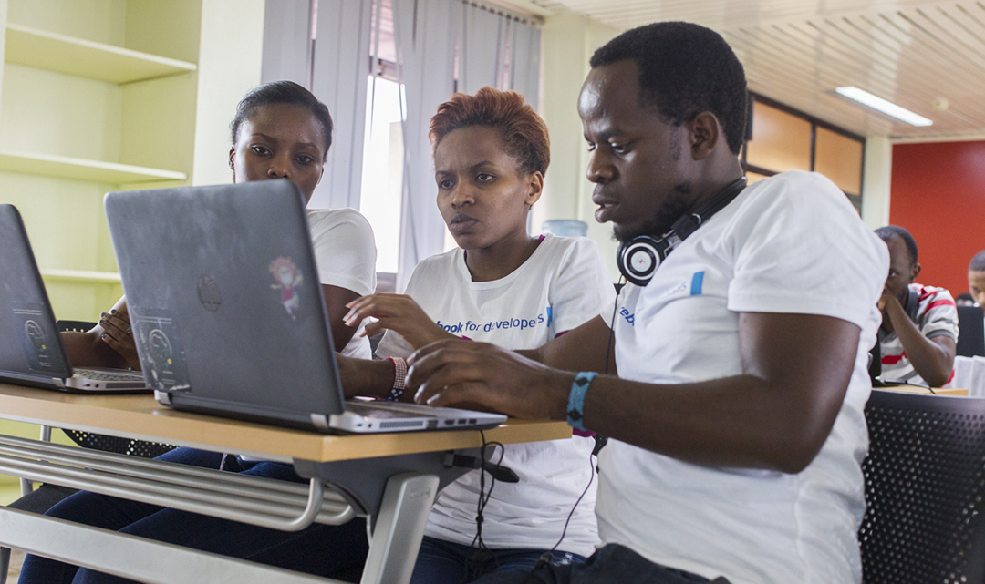 Three CMU-Africa students work diligently on their computers
