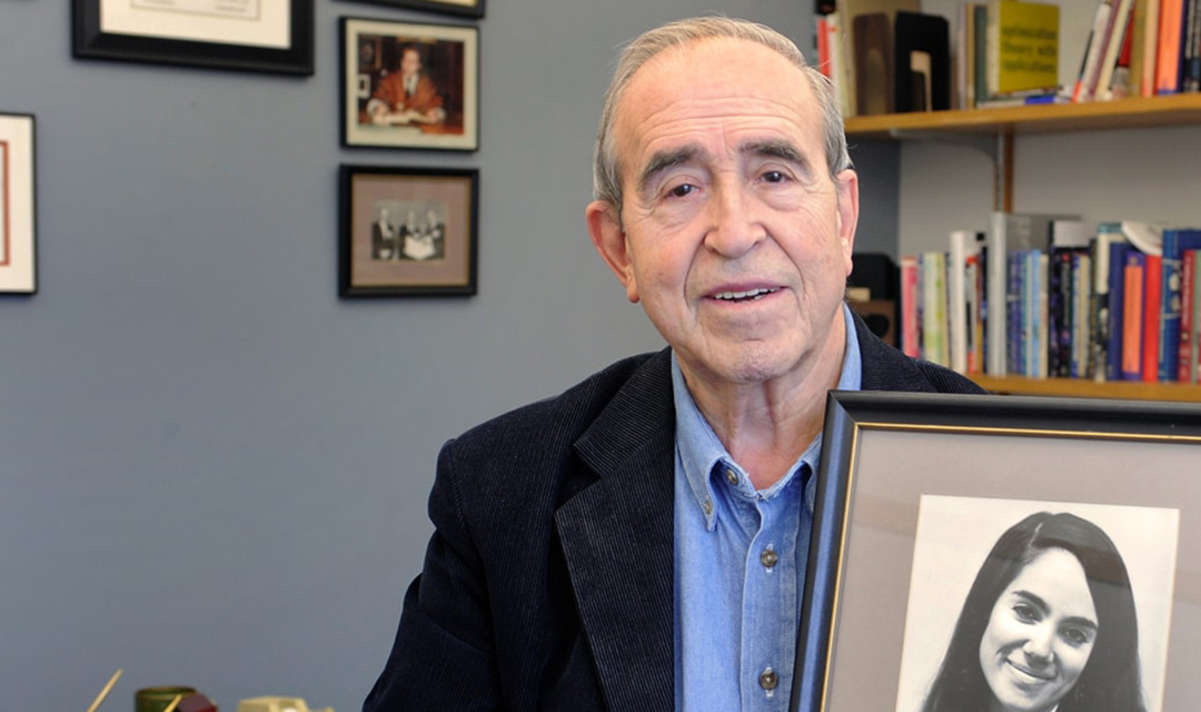 Angel Jordan, University Professor Emeritus, holding a photograph