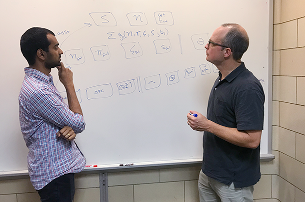 Washburn and student talking standing by whiteboard