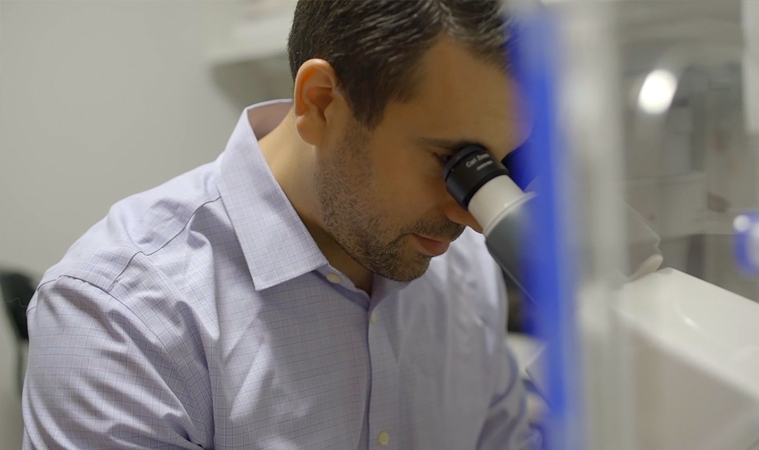 Feinberg looking into microscope