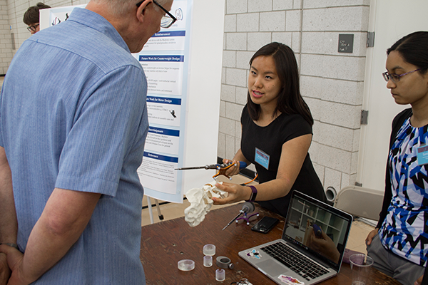 Student talking beside research poster