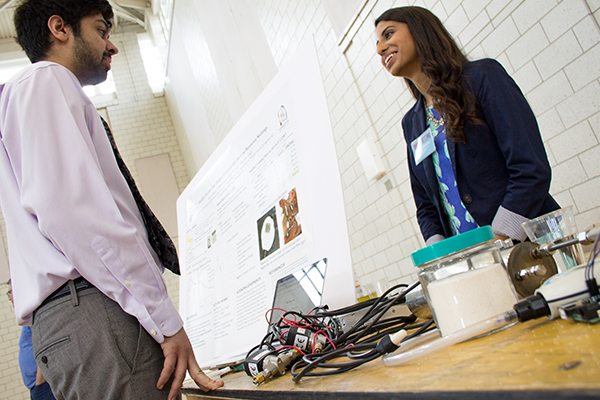 Student talking beside research poster