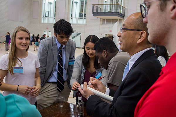 Students and faculty talking at table