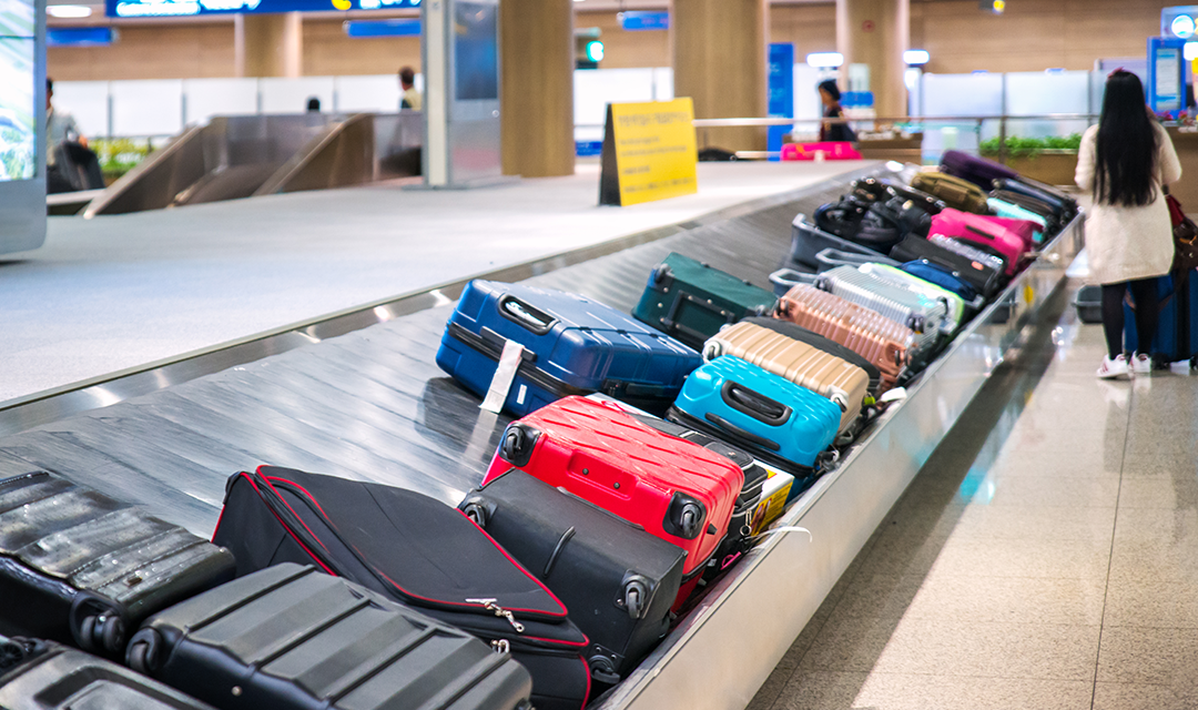 Multi-colored luggage on an airport baggage carousel