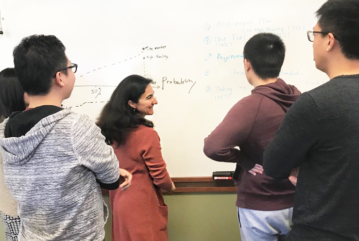 Cécile Péraire in front of a white board teaching students