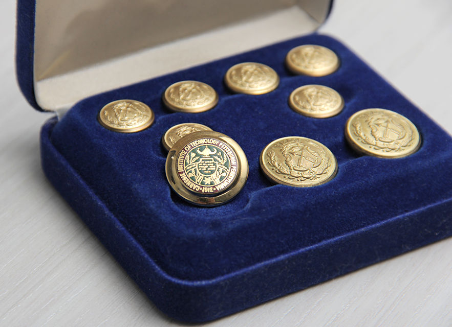The Carnegie Institute of Technology logo on the button, pictured in a jewelry box