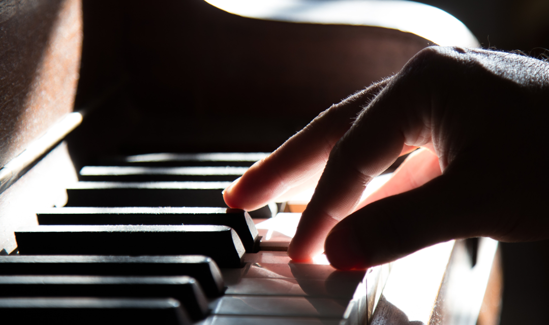 Hands playing a piano