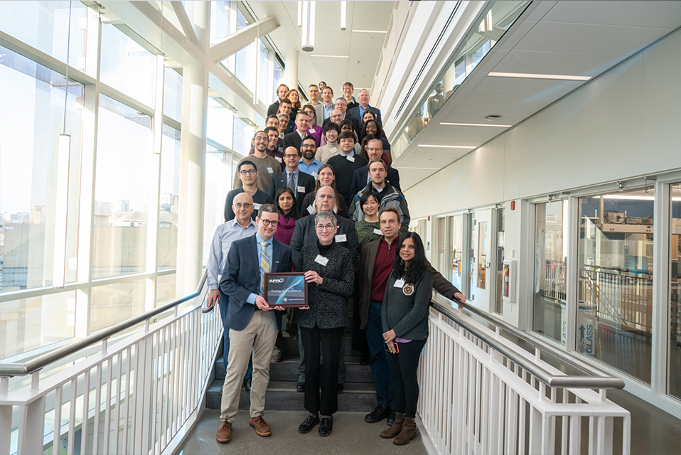 A group of over forty researchers standing on a flight of steps in Scott Hall.