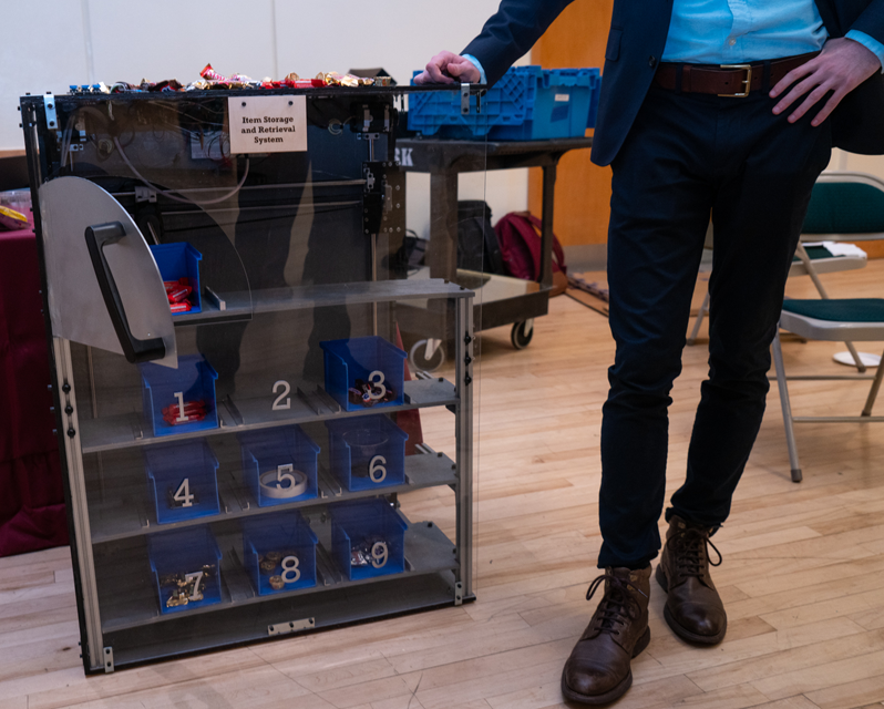 Student standing next to different drawers on shelves