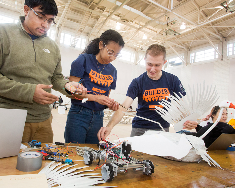 Students working with a small motorized car and paper cut like wings