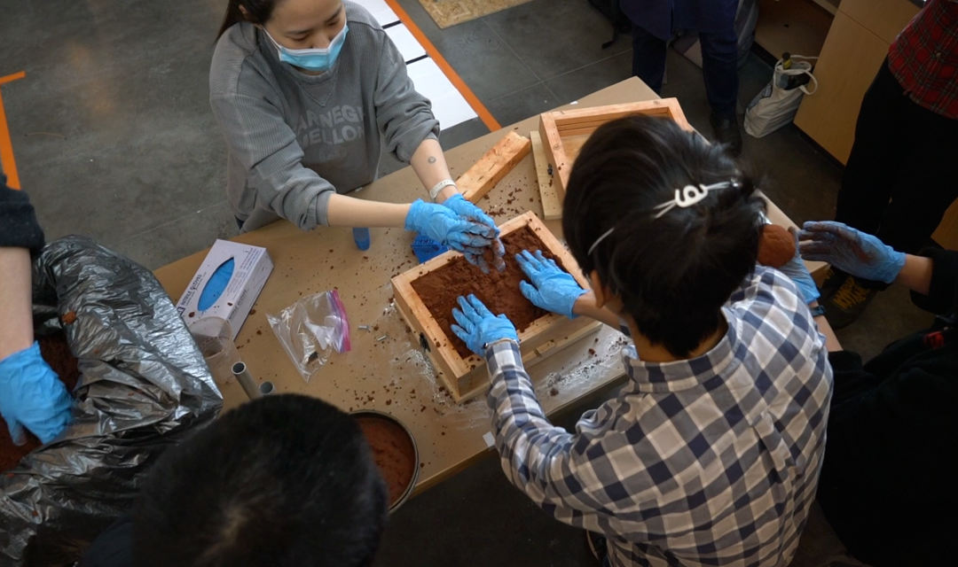 Two students working on a metal casting