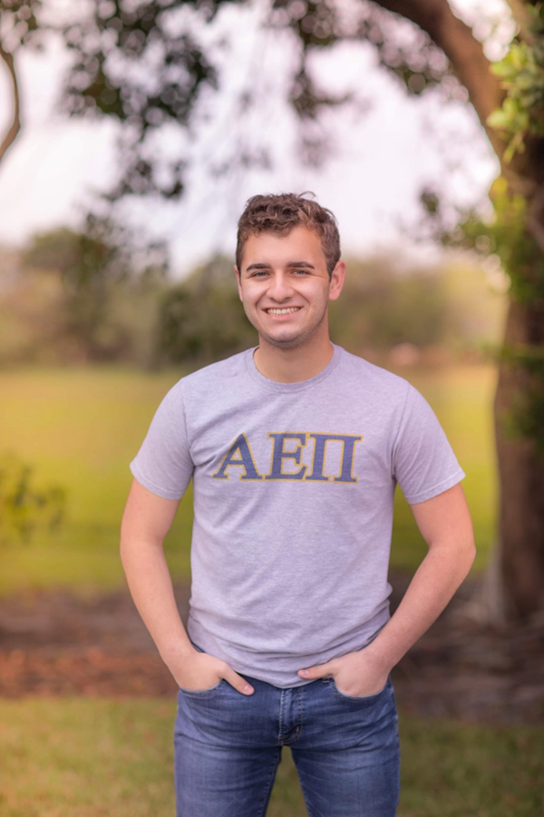 Student outside wearing fraternity shirt