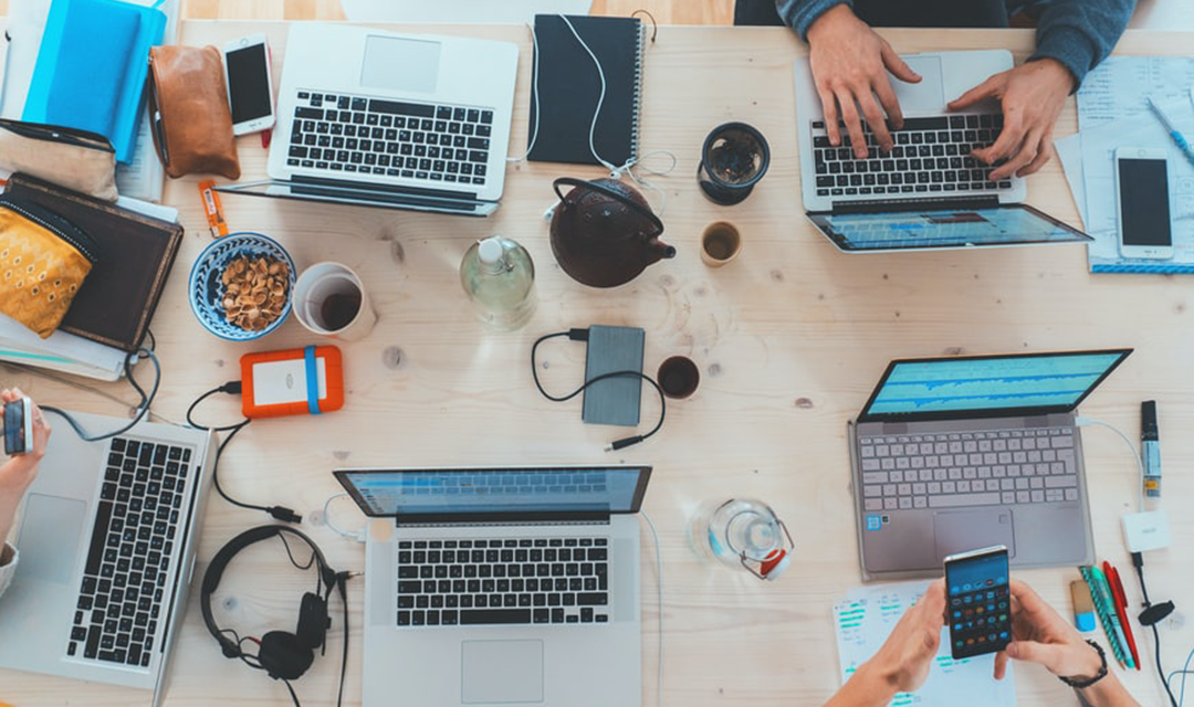A tabletop with multiple laptops