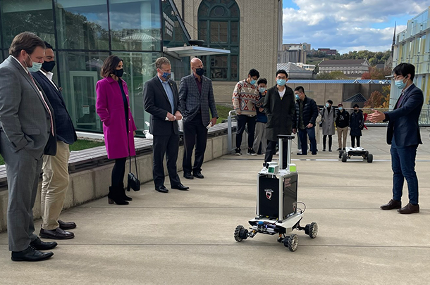 Group of people outside staring at a robot