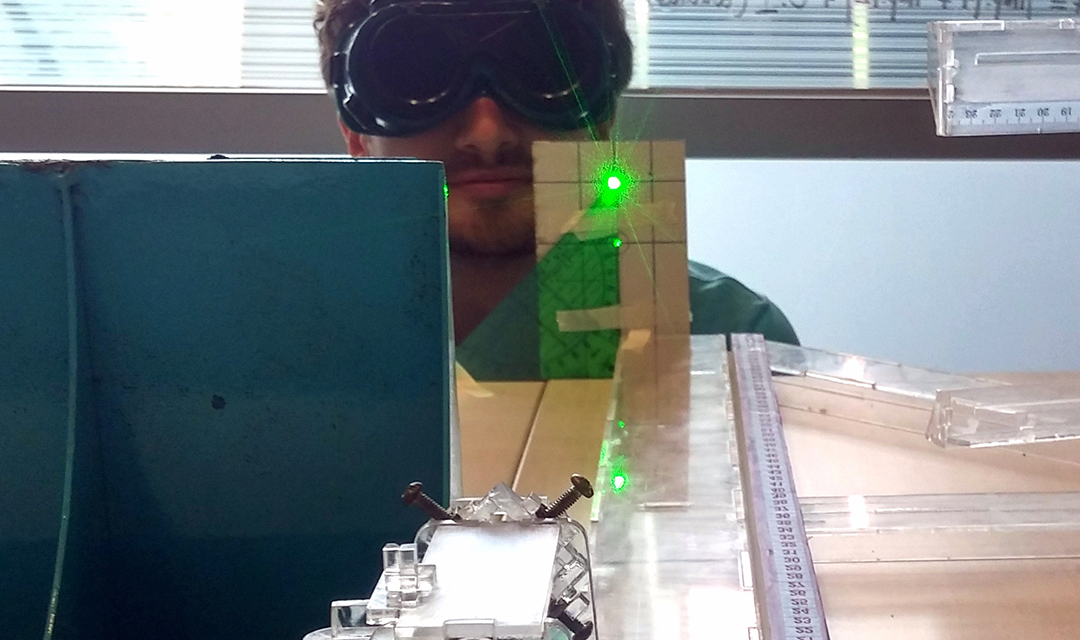 Man wearing googles while directing laser beam at camera
