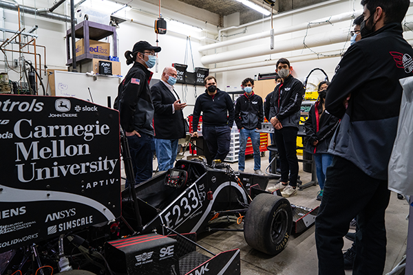 Group of six people around the racecar