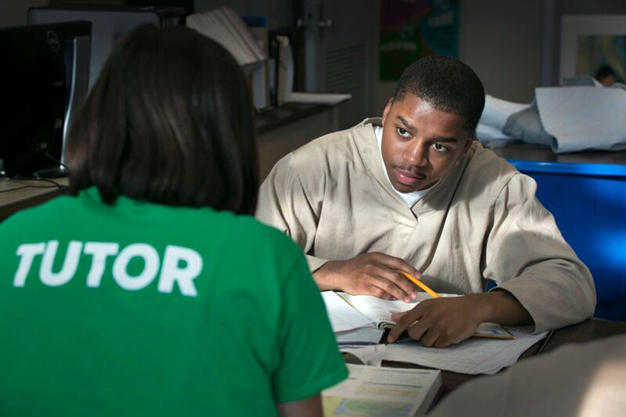 Student sitting at a table studying with a tutor