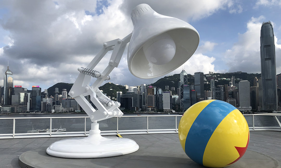 Iconic Pixar lamp and ball statue in a city