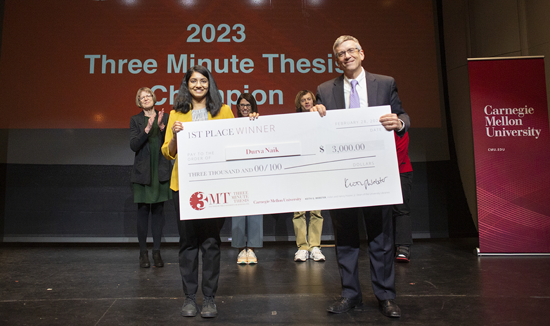 3MT winner and Provost Jim Garrett hold up the winner's check