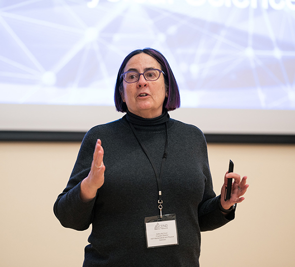 A woman talking in front of a powerpoint presentation