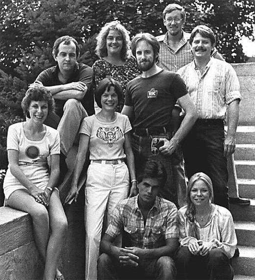 An old photograph of nine people standing on steps