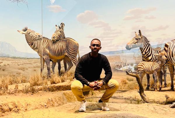 A student in front of a zebra mural