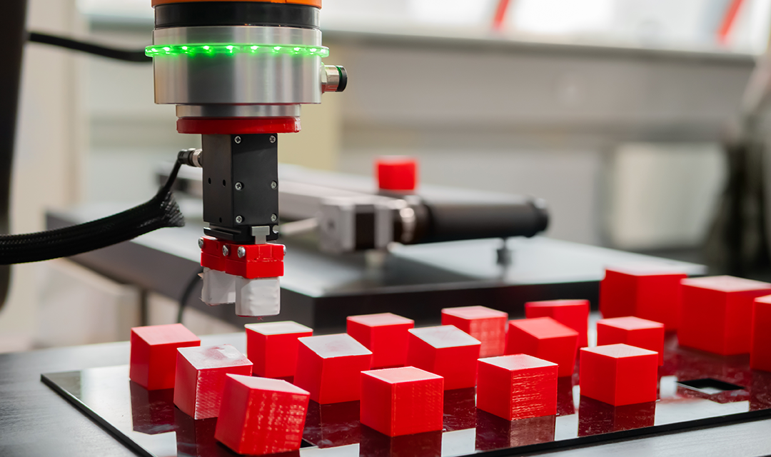 Robot with magnet attached picking up blocks