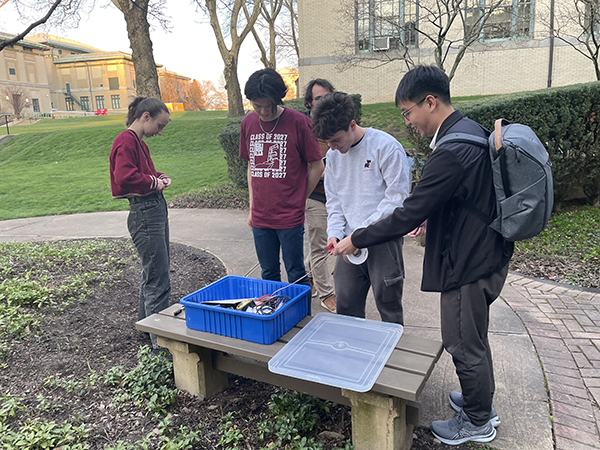 Five students outside working on an electrical project