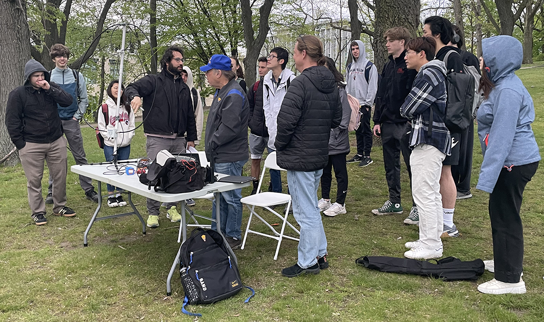A group of students outside around a table with wiring