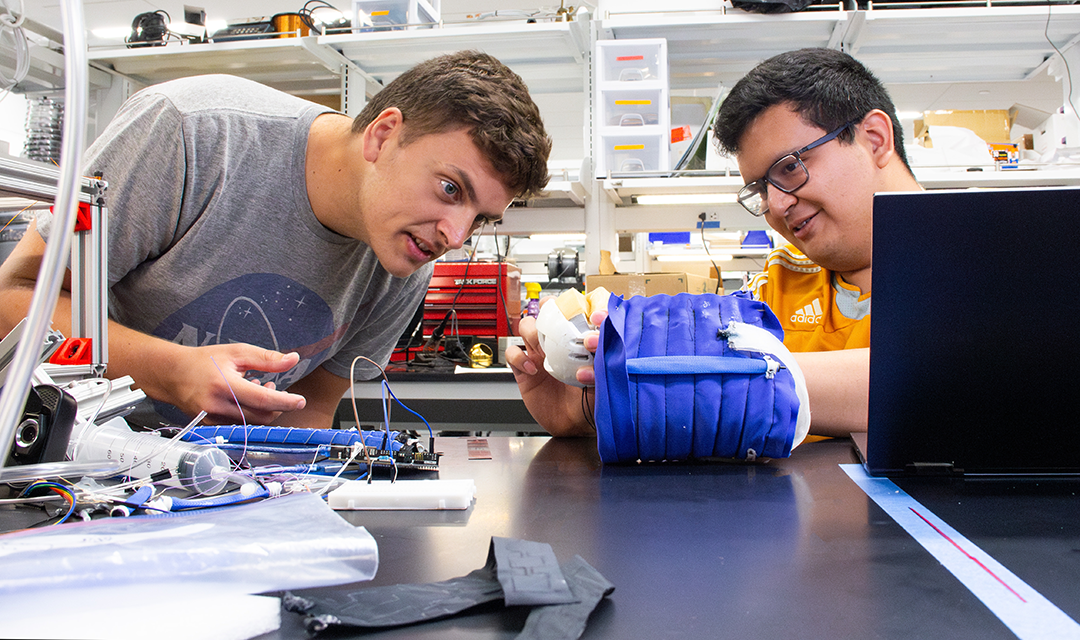 Two students working on an organic robotic project in a lab