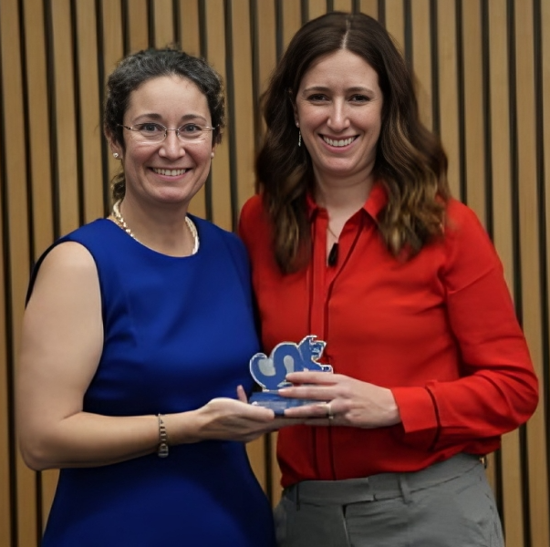 Two women holding an award