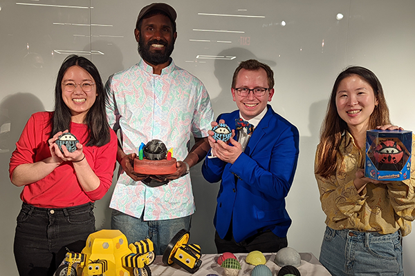 Four people each holding a small object