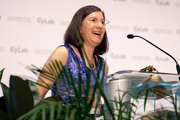 A smiling woman presenting at a podium