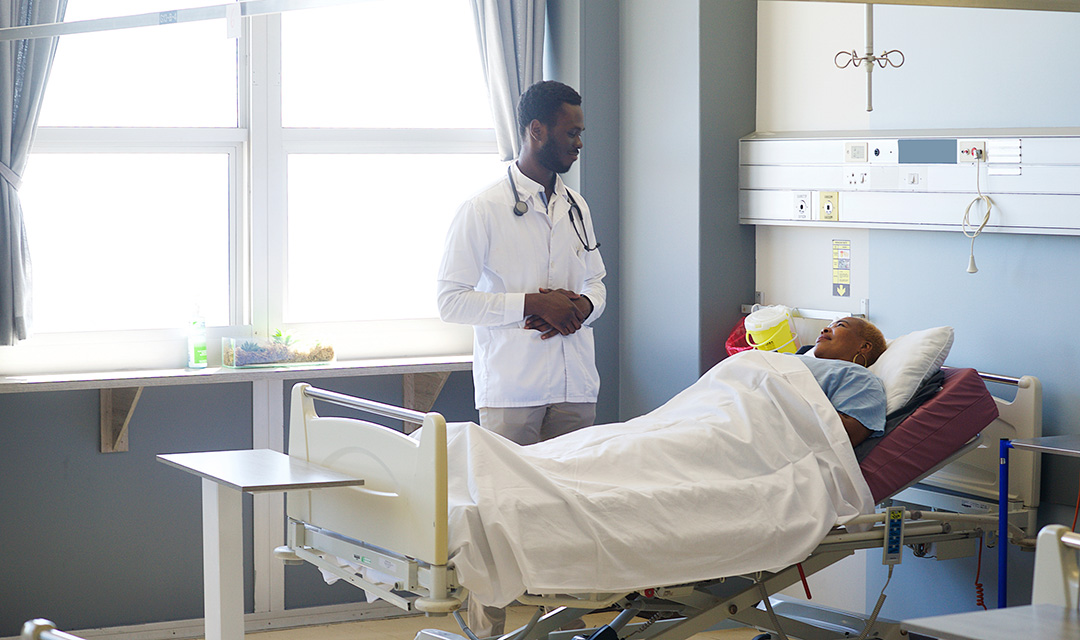 A doctor standing next to a patient in a hospital bed
