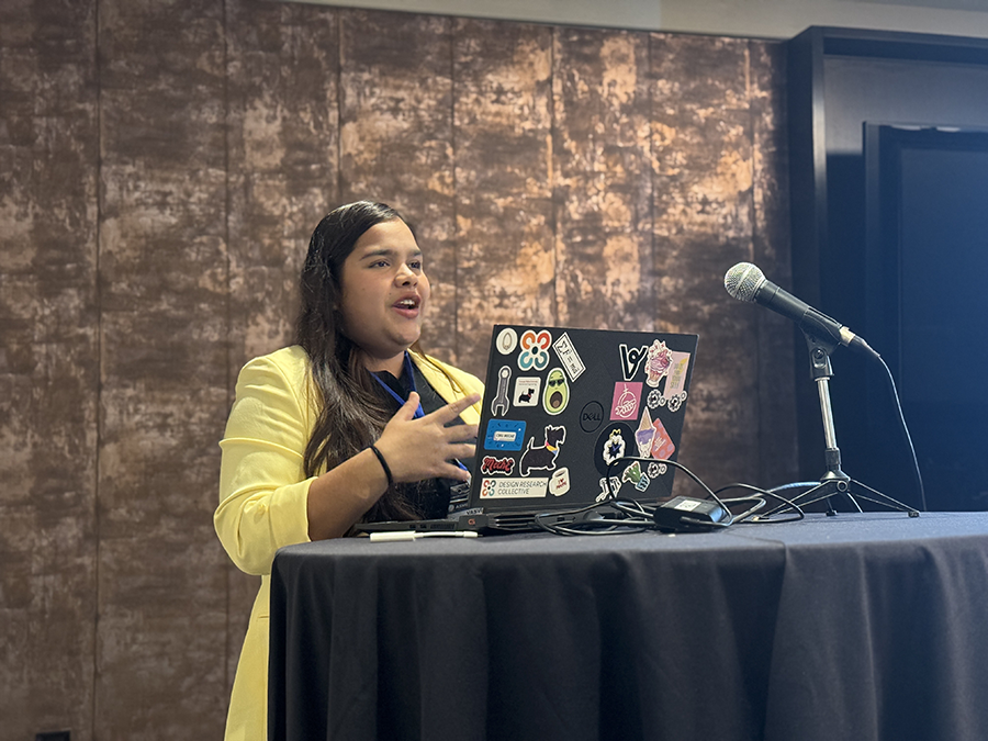 Girl presenting at a podium with a laptop