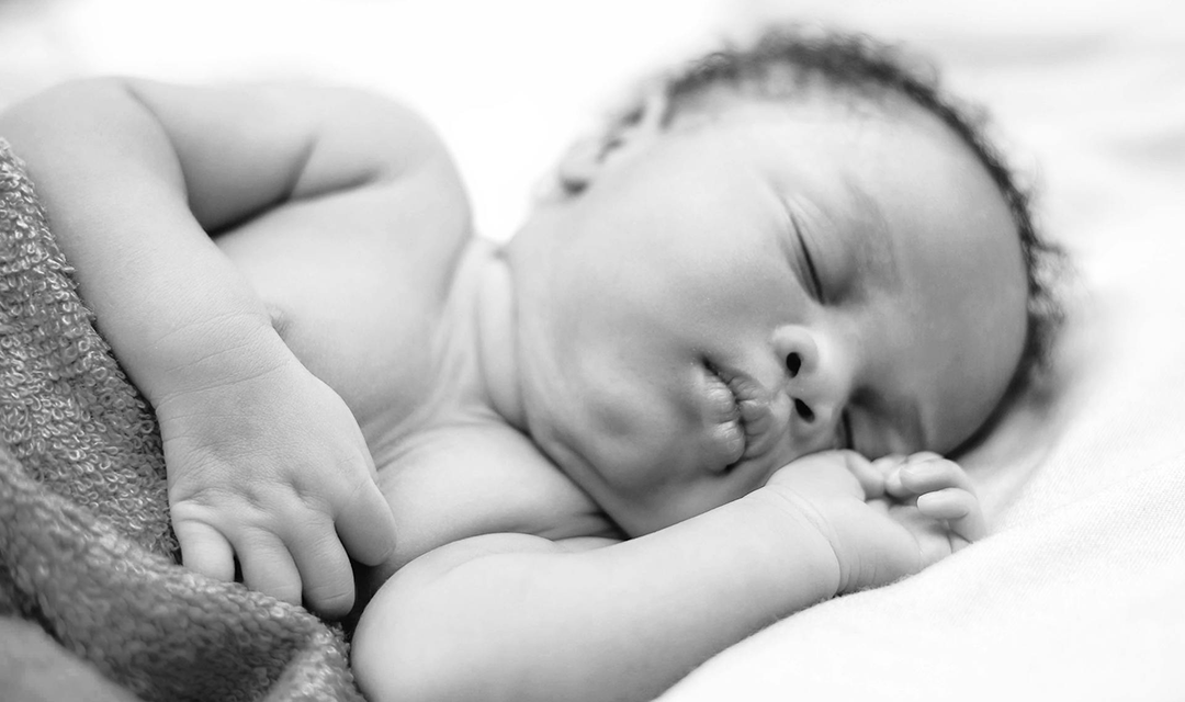 Head of a baby being cradled in hands