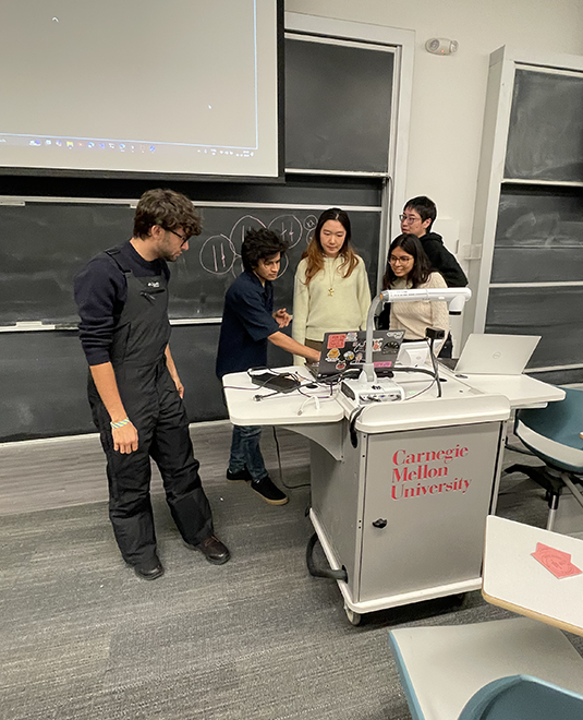 Students presenting with a powerpoint presentation displayed above them