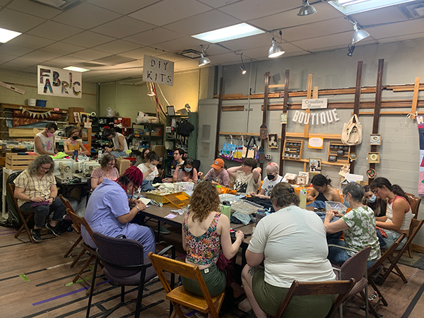 A roomful of people working on mending projects