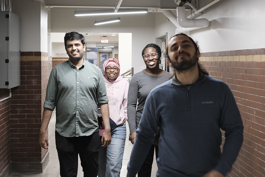 Group of four students walking down a hallway