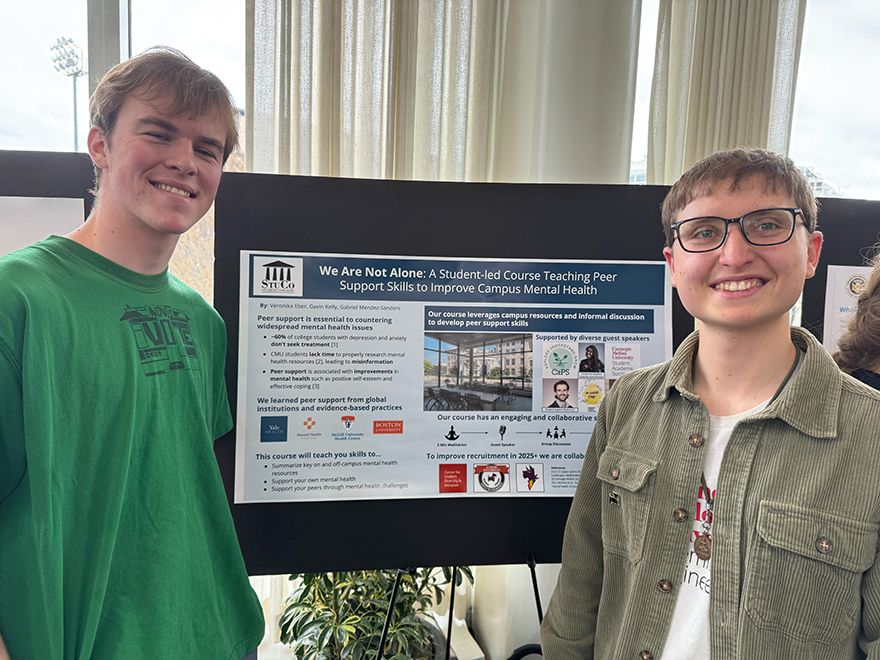 Two students standing with their project poster