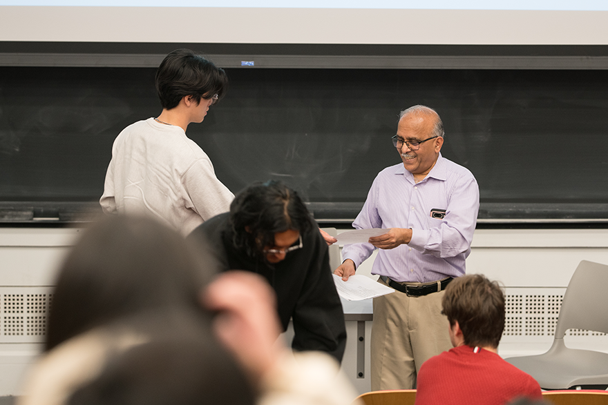 A student handing in an assignment to Kumar Bhagavatula