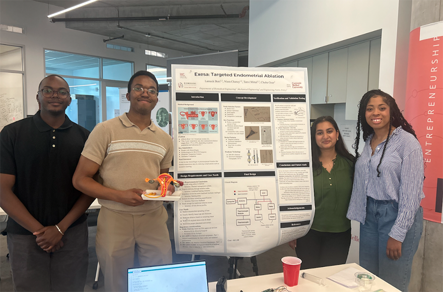 Four people standing around a poster