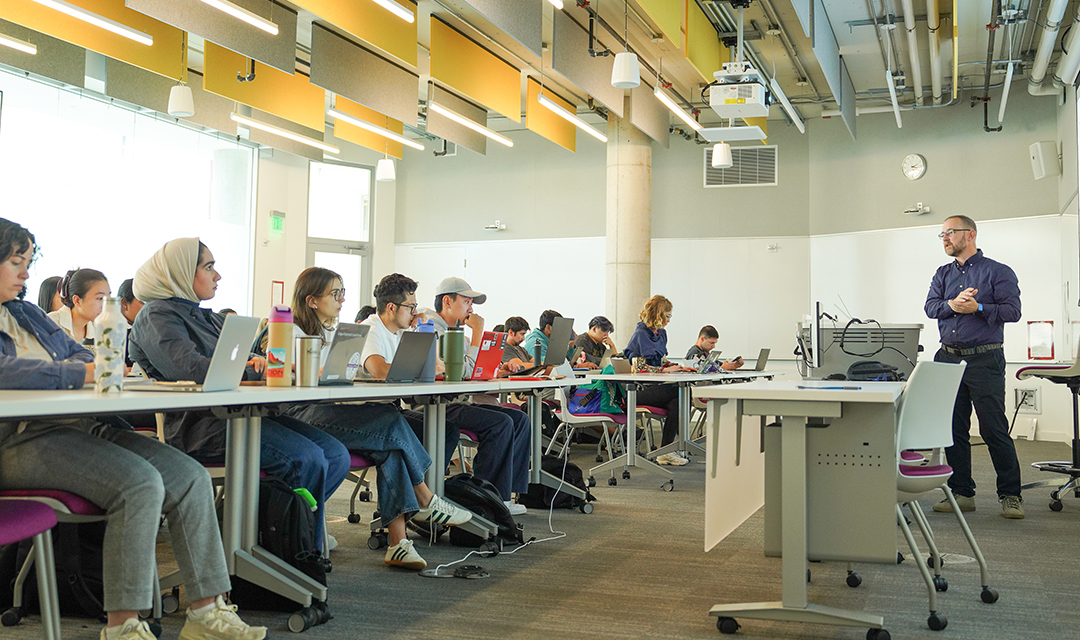 A classroom setting with students actively engaged during a lecture, highlighting modern learning environments.
