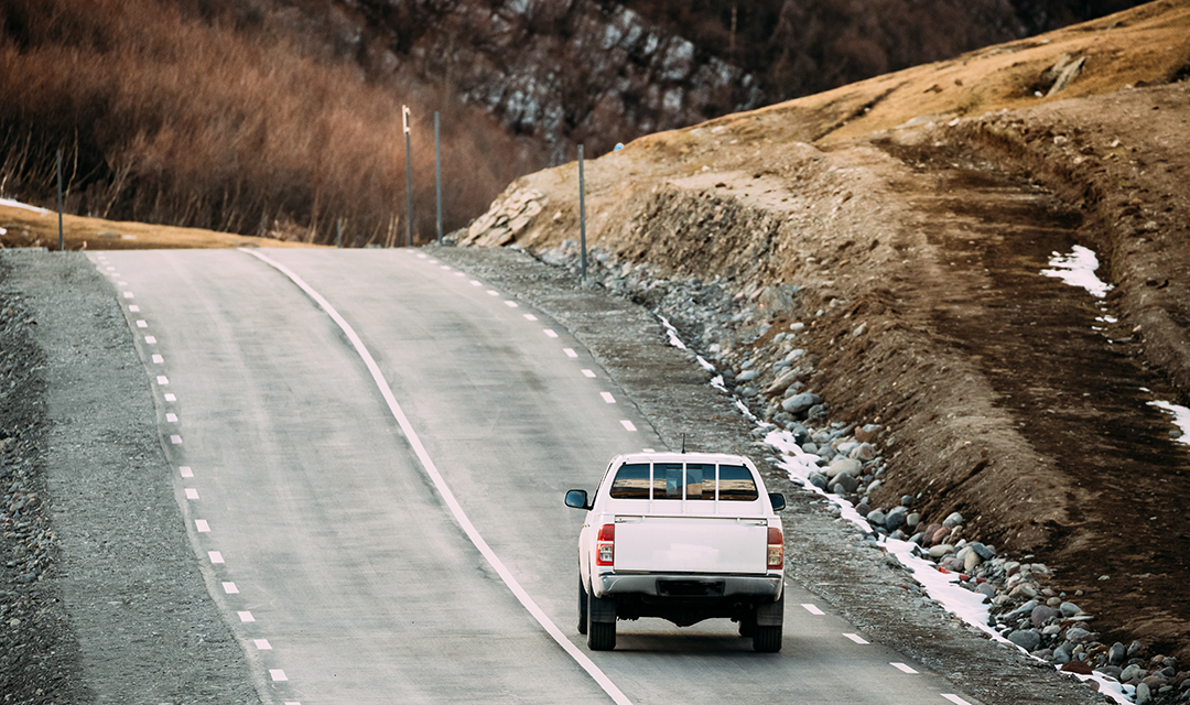 A pickup truck driving on an open road