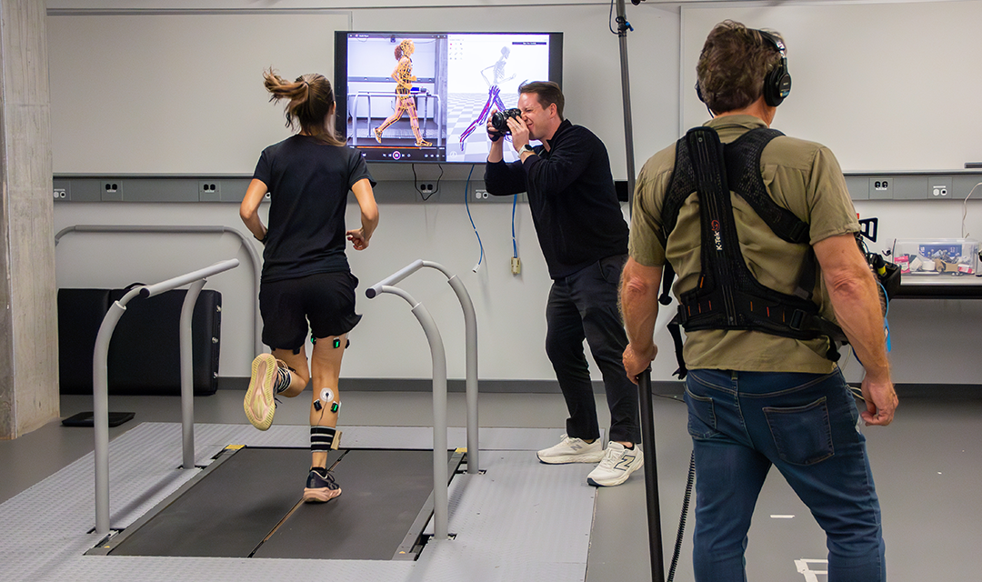 Woman running on a treadmill while a man photographs her