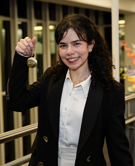 Lara Abdelmohsen holding a medal from the 3 minute thesis