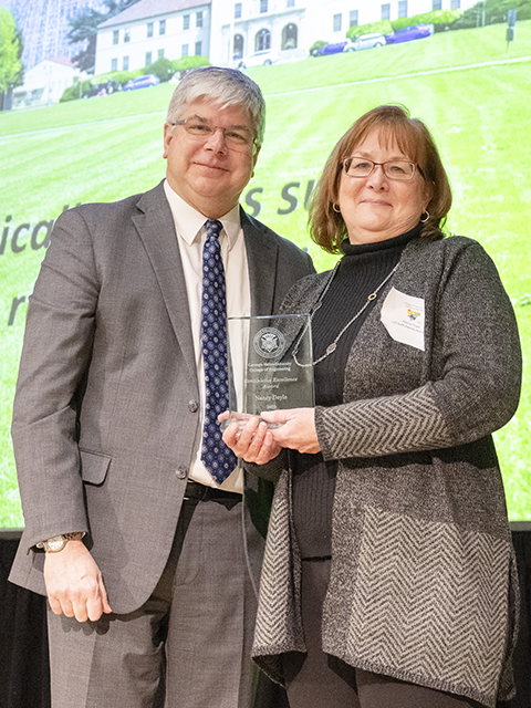 Nancy Doyle standing with Dean Sanders holding her award