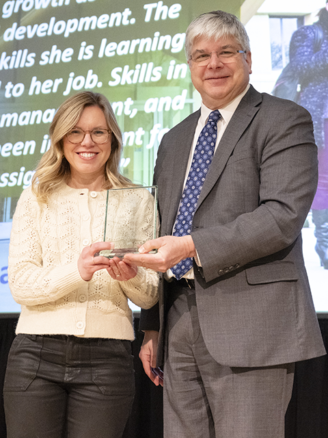 Jenny Hurtst standing with Dean Sanders holding her award